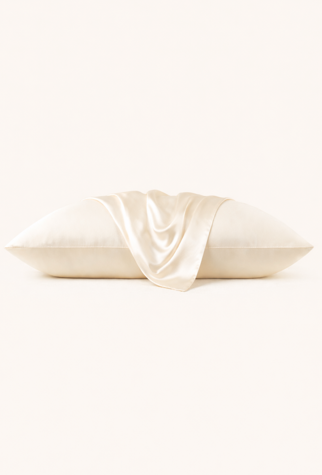 Cream-colored pillowcase with a draped fabric accent on a white background