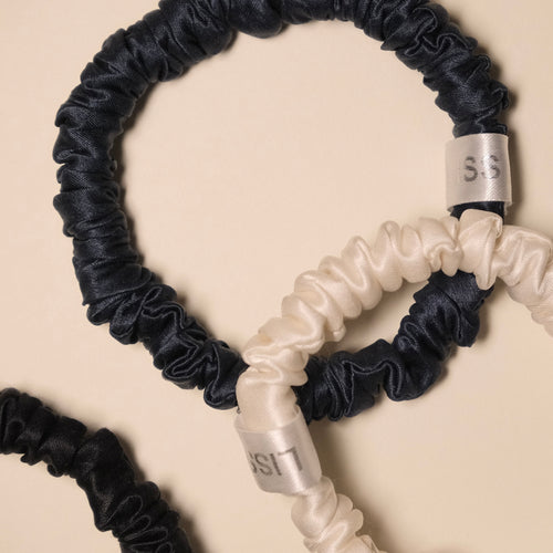 LISS silk scrunchies mini set in white, black, and navy on a beige background
