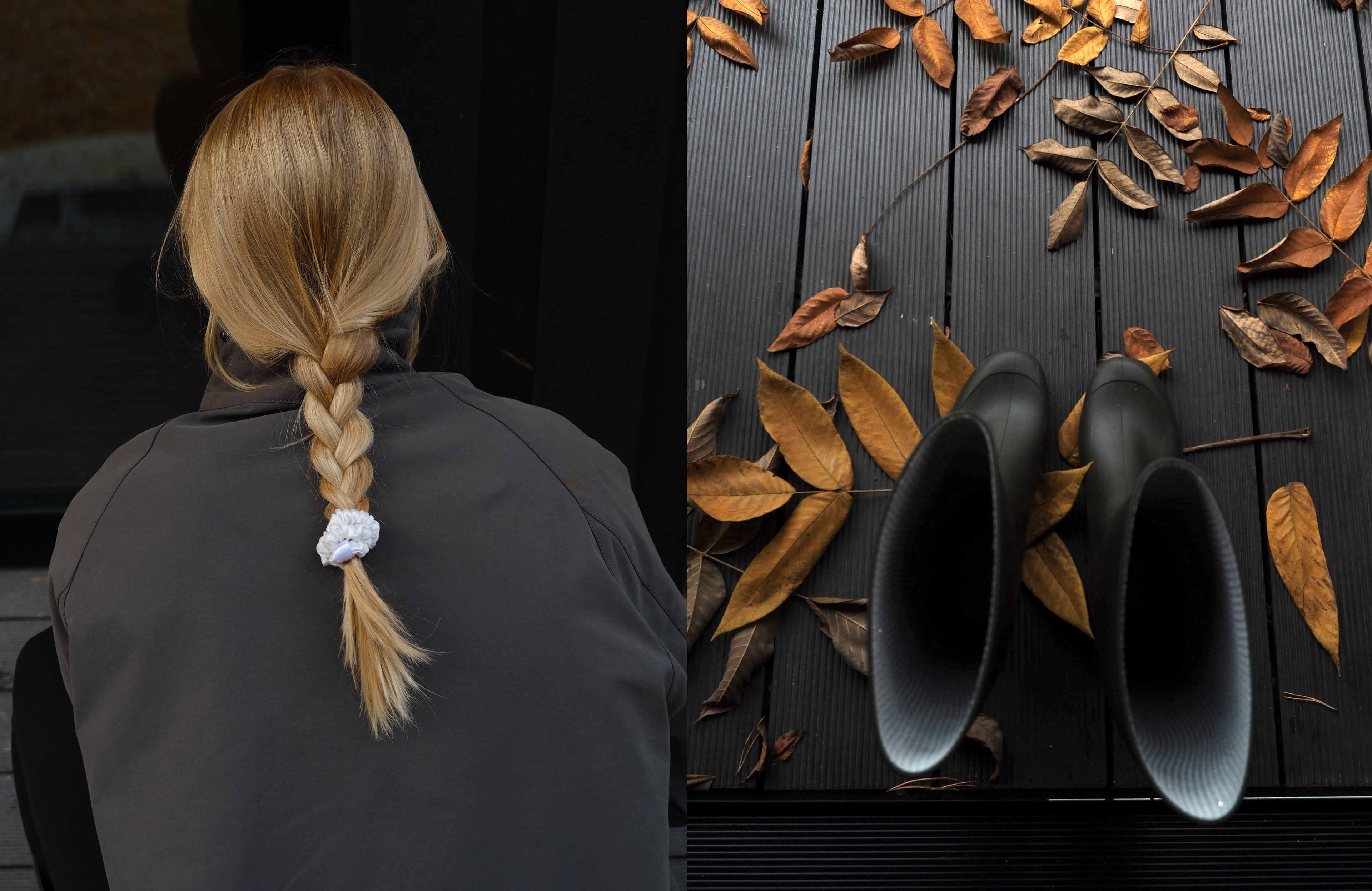 Woman with blonde braided hair wearing a gray jacket and silk scrunchie, autumn leaves and black boots on wooden floor — LISS Mulberry silk hair accessory.