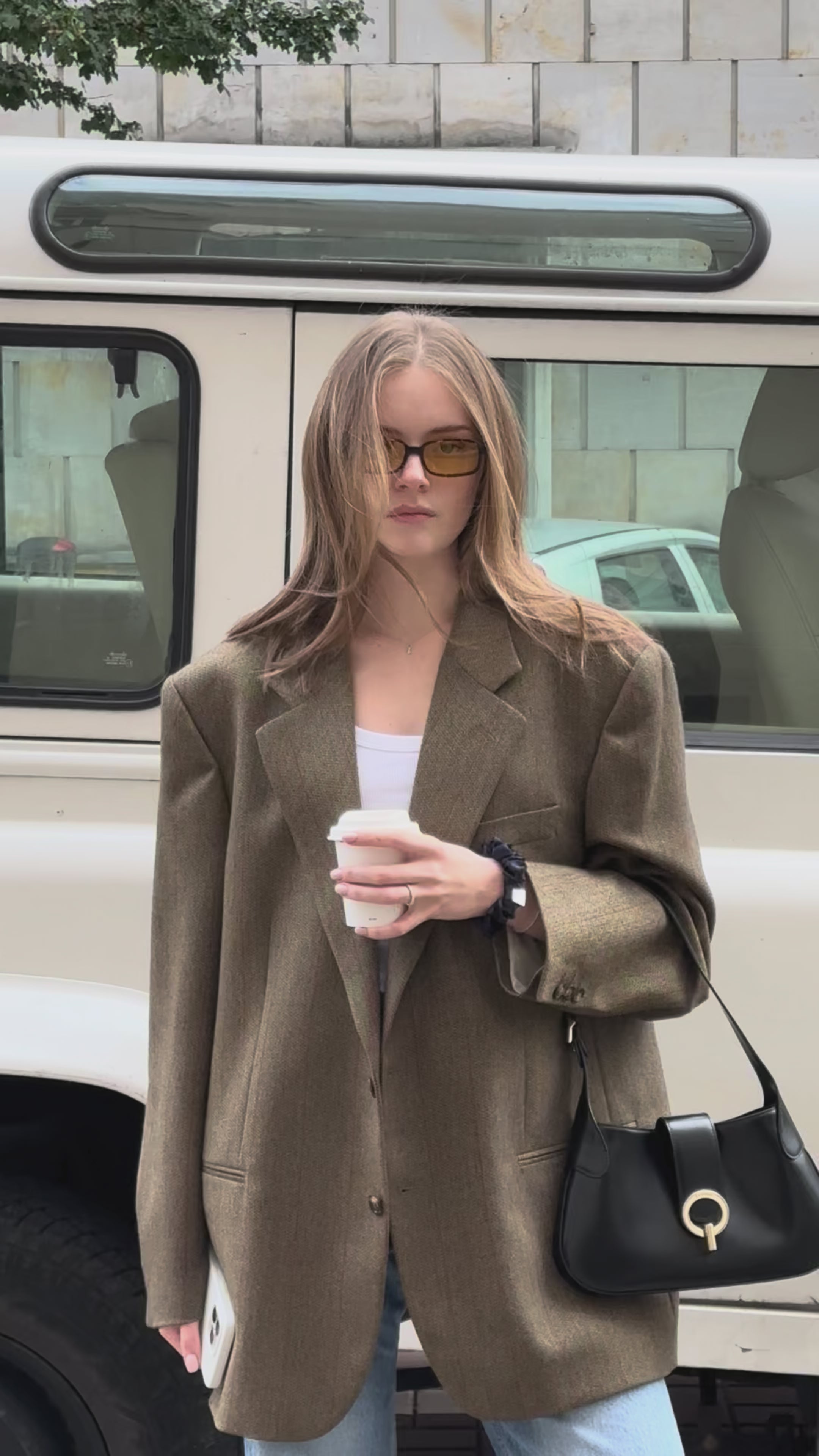 Video of girl with blonde hair styled with LISS 100% mulberry silk scrunchie, wearing oversized blazer, street fashion look in Warsaw.